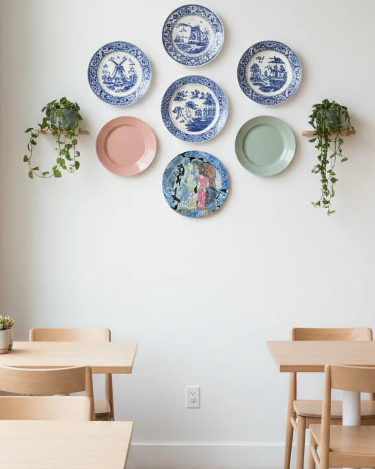 Round artwork with two figures in a floral patterned setting on a white background